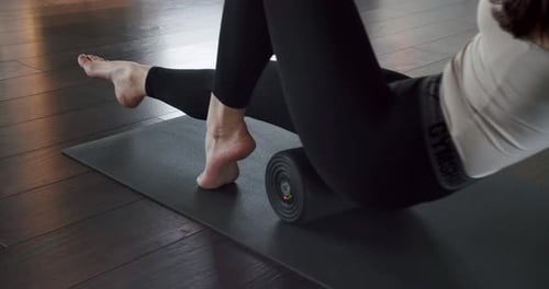 Woman Stretches Quads with Vibrating Foam Roller
