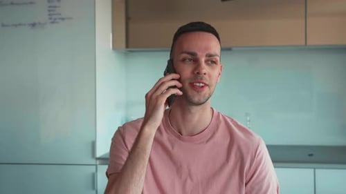 Pleasure Talk Close Up Portrait of Young Caucasian Positive Man Talking on Mobile Phone with Friends