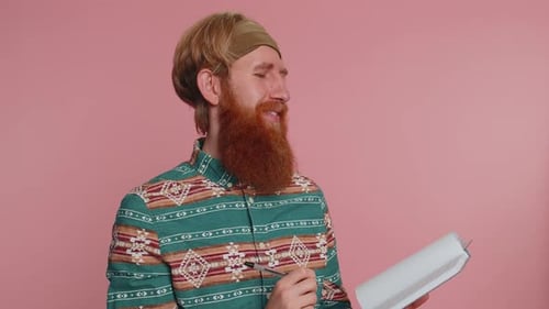 Bearded Adult Considers Notes and Writes