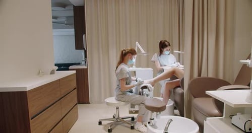 Two Masters Beautician Doing Foot and Hand Care Treatment at Luxury Nail Studio