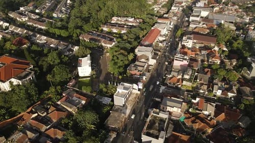 Aerial View Of Vehicles Passing Between Houses And Buildings In Jakarta, Indonesia - drone shot