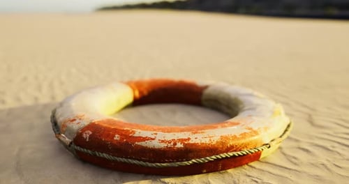 Lifebuoy descansando en una playa de arena durante la puesta de sol en la orilla del océano