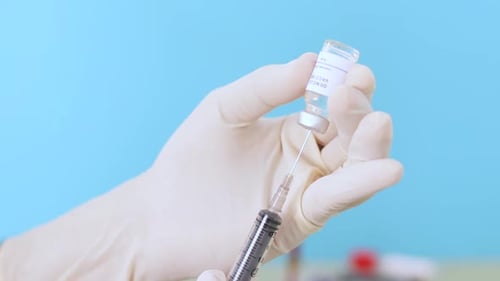 Close up of hands doctor filling The syringe with dengue vaccine at hospital.