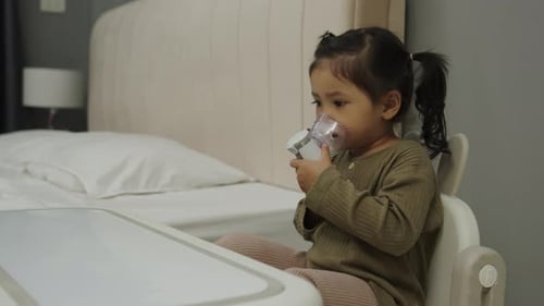 Young Child with Nebulizer in Bedroom