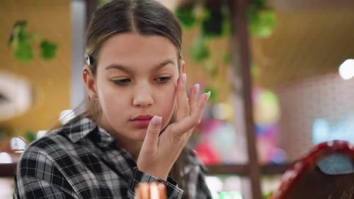 Closeup View of Young Girl Applying Serum Makeup on Face for Skincare Routine