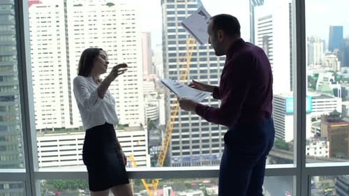 Young Businesspeople with Documents Fighting in Office Analyzing