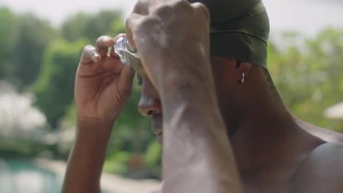 Black Swimmer Putting on Goggles before Outdoor Training