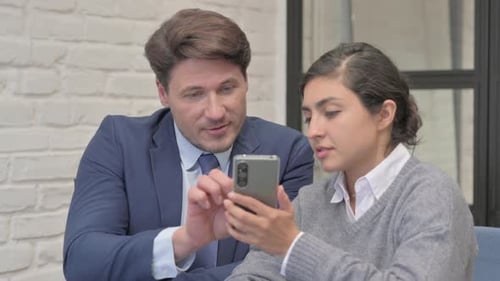 Business People Using Phone in Office