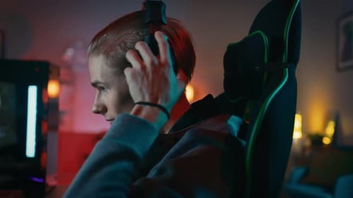 Man Puts on Headphones at His Computer at Home