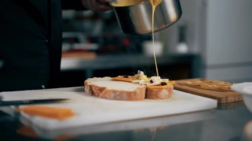 Closeup in a Professional Kitchen the Chef Pours Cheese on Bruschettas Restaurant Serving