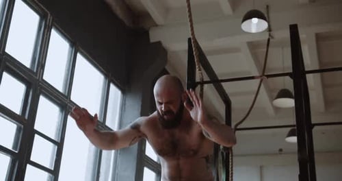 Athletischer kaukasischer Mann ohne Hemd macht Burpee-Übungen während eines extrem funktionellen Trainings in Größe L