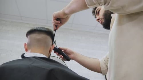 Barber Giving Client a Haircut in Barbershop