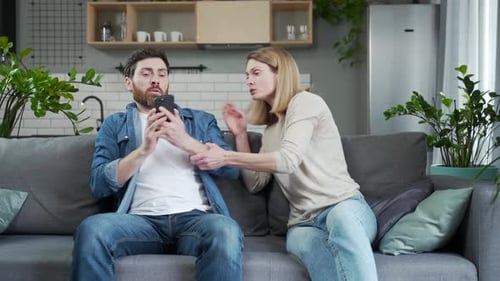 Irritierte junge Frau findet auf dem Telefon des Ehemanns eine Nachricht von Untreue, die ihn trifft