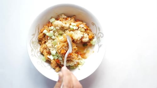 Mixing Chicken Quinoa Salad Bowl with Spoon