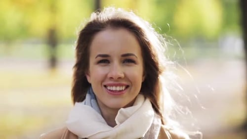 Beautiful happy young woman smiles in autumn park nature lifestyle expression