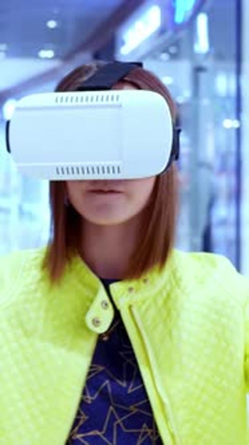 Jeune femme portant un casque de réalité virtuelle dans un environnement de centre commercial moderne avec des lumières vives