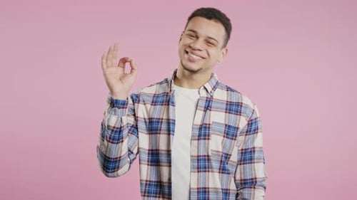 Smiling Young Adult Giving OK Hand Gesture