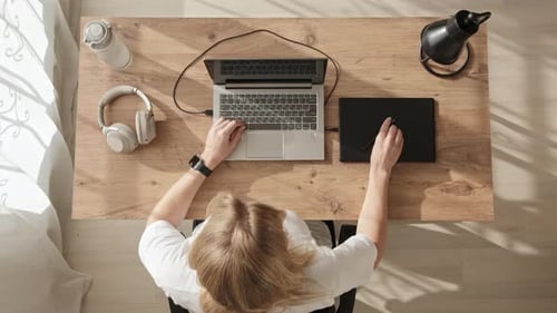 Top Down View Freelancer Woman in White Tshirt Sits Down at Her Desk and Starts Drawing on Graphics