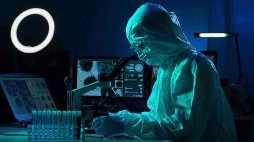 Scientist Uses Microscope in Dark Laboratory