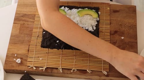Enjoy a close-up look as a woman skillfully prepares sushi at home