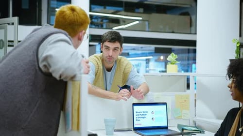 Junge Büroangestellte chatten während des Arbeitstages an der Kabinenwand