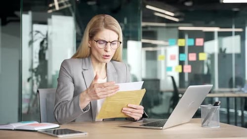 Worried Woman Reading Document at Her Desk