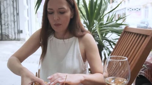 Caucasian Woman Eating Tasty Club Sandwich with Glass of White Wine on Lunch While Sitting Outdoor