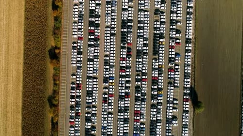 Aerial footage of finished cars ready to be shipped on huge distribution center