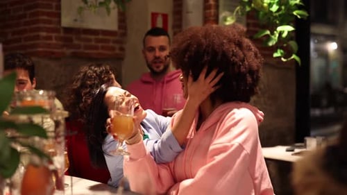 happy friends having fun at a bar counter drinking beer and celebrating party.