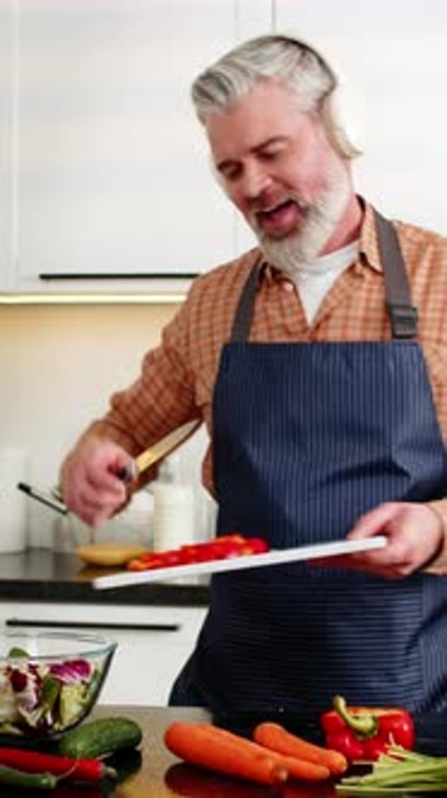 Happy Man Dancing and Cooking in Modern Kitchen