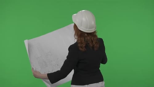 Back View of an Architect Woman Holding a Plan of a Building in Her Hands A Business Woman Studies