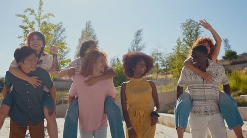 Friends Giving Piggy Back Rides on Sunny Day