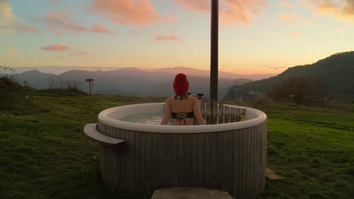 Young Woman Glamping in Outdoor Wooden Hot Tub