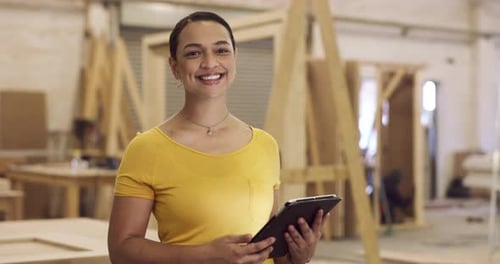 4k video footage of a young businesswoman in her carpentry workshop using her digital tablet