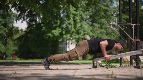 Young Man Exercising with Push-Ups in Outdoor Park