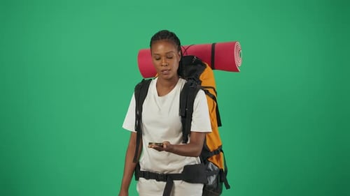 Backpacker Woman Using Compass for Direction on Green Screen