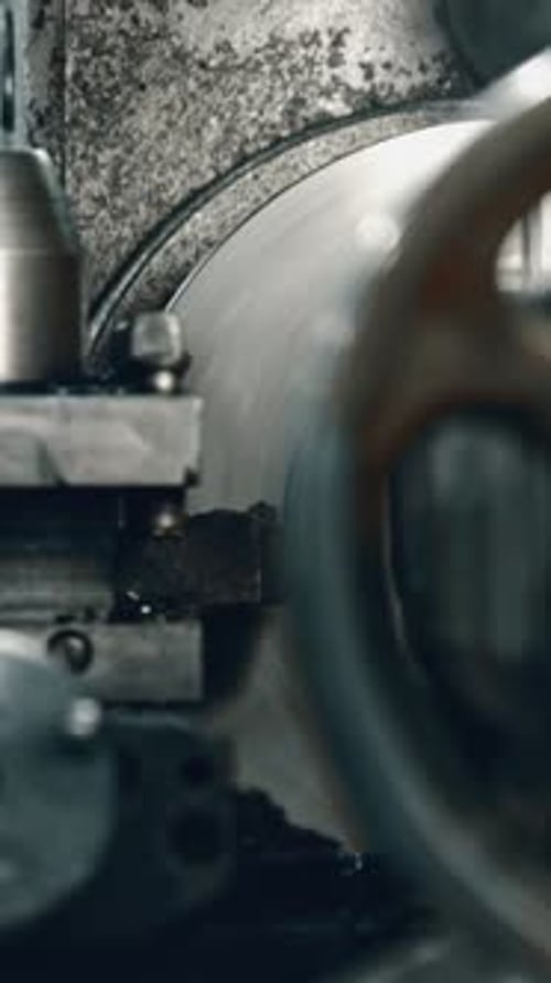 Metalworker using lathe machine in factory workshop