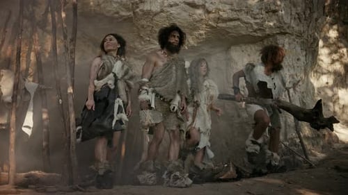 Tribu de quatre chasseurs-cueilleurs en peau d'animal tenant des outils à pointe de pierre, posant à l'entrée