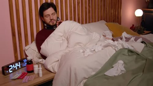 Homme mûr malade souffrant d'écoulement nasal prenant des médicaments au lit