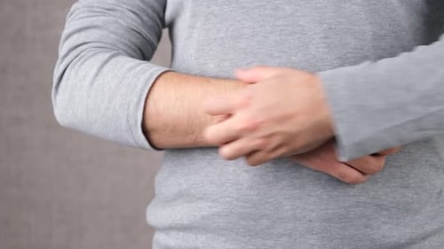 Adult Scratching Arm Due to Itch