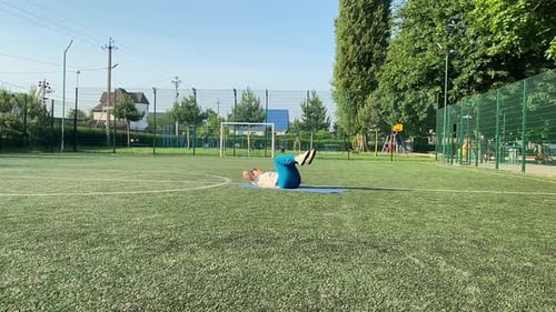 Jovem mulher se aquece na área esportiva ao ar livre