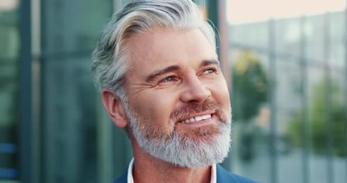 Smiling man with gray hair in city environment