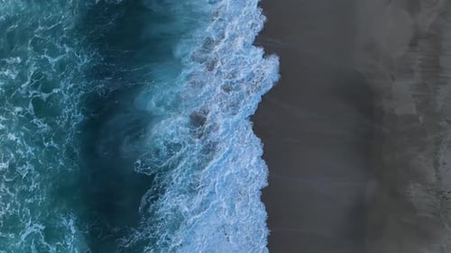 Cinematic Top Down Abstract Aerial View of Ocean Waves Crashing on Rocky Shoreline