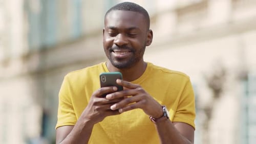 Face African American Attractive Man Using Phone Stand on Street Smile Sunlight Sunset Cellphone