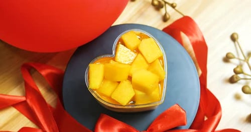 Mango Chunks in Heart Container with Red Ribbon