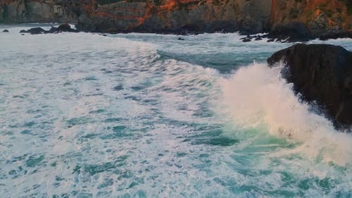 Foamy Waves Rolling Stone Shoreline Closeup. Picturesque Drone View Stormy Sea Water Washing Empt...