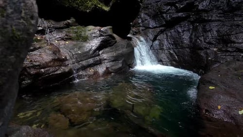 Wasserfälle und fließendes Wasser bilden Pools, in denen das Sonnenlicht die Umgebung beleuchtet