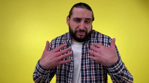 Man Laughing and Gesturing on Yellow Background