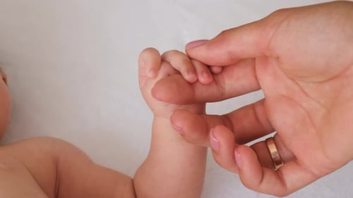 Mom Strokes Baby's Hand Selective Focus