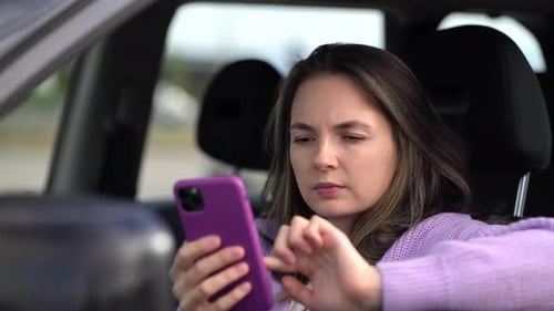 Woman Uses Smartphone in Car